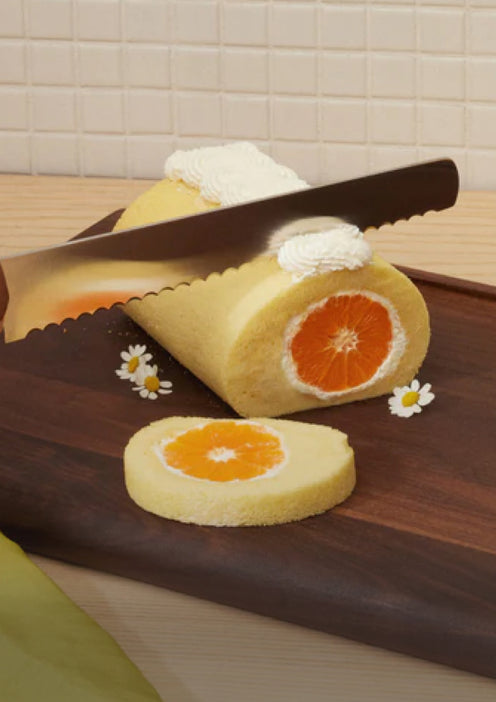 Serrated Slicing Knife cutting a dessert on the Walnut Cutting Board