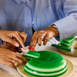 hands cutting green jello