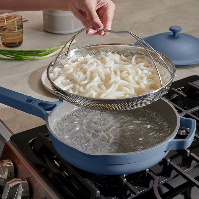 Blue always pan on stovetop with noodles