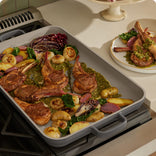 searing lamb chops and vegetables on stove