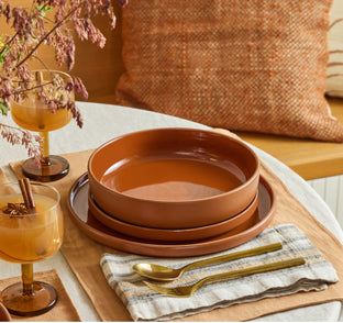 terracotta dinner bowls, salad plates and dinner plates on table 